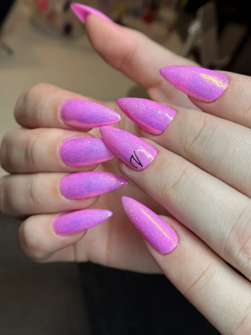 Pink shimmer stiletto nails with a hand-drawn accent