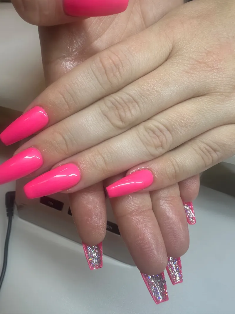 Neon pink coffin nails with holographic glitter accents